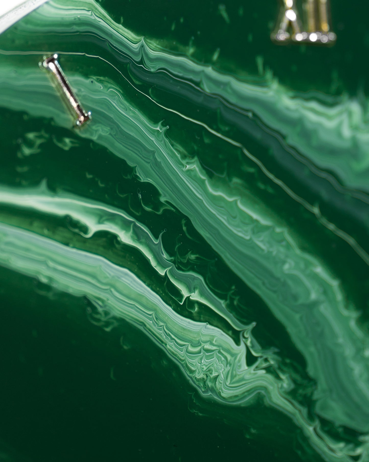 dettaglio sfumatura di colore e numero romano di orologio da parete in resina epossidica effetto marmo Verde Alpi
